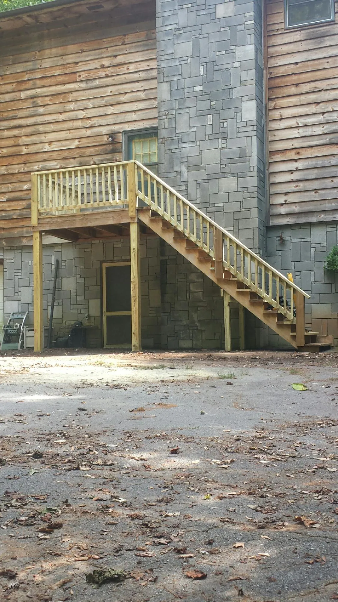 New pressure treated deck and stair landing on a log home in Helendale