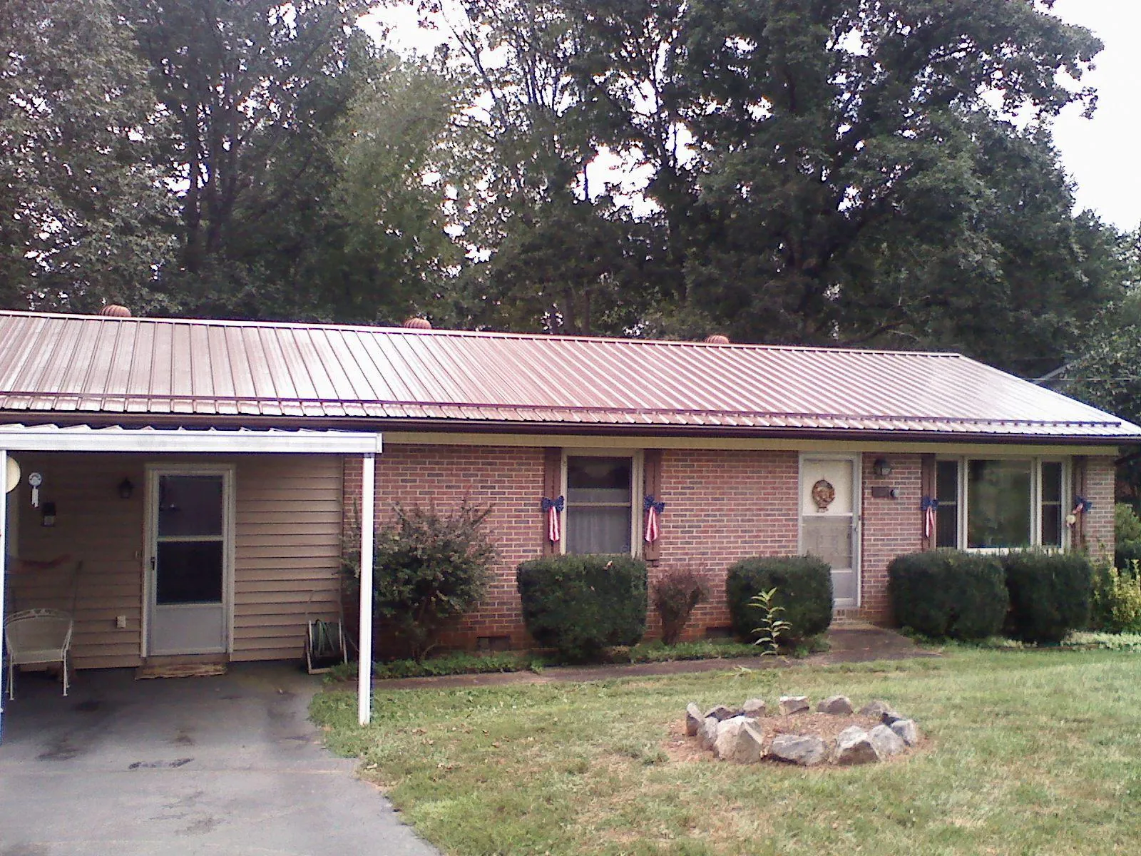 Bronze metal roof and carport on a brick ranch home — Roof Repair work by our crew in Helendale